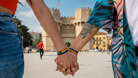 Two people holding hands in front of the Torres de Serranos in Valencia, Spain (Credit: Visit Valencia)