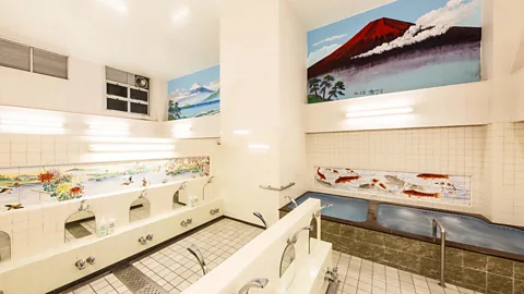 A room in a bathhouse with pools and faucets, with wall murals of Mount Fuji and koi swimming in a pond (Credit: Mizuki Uchiyama)  (Credit: Konparu-yu)