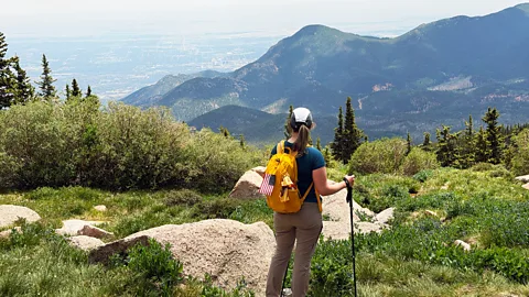 A woman surveys the vast view from a mountaintop (Credit: Rob Shearer)