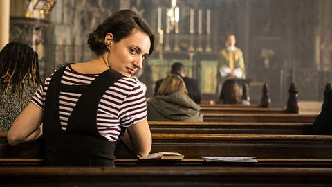 Phoebe Waller-Bridge looks back at the camera while sitting on a pew in church in Fleabag (Credit: Alamy)