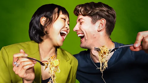 A man and a woman laughing while eating spaghetti (Credit: BBC/ Serenity Strull/ Getty Images)