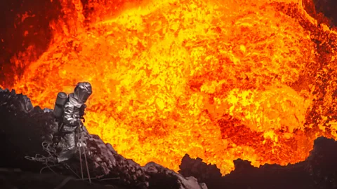 Bradley Ambrose/Caters Scientist Geoff Mackley investigates the interior of the Marum Volcano in Vanuatu. He stood only 30 metres from the boiling lava for 45 minutes. (Copyright: Bradley Ambrose/Caters)