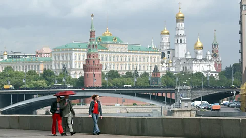 In Moscow, pedestrians stroll by the walls of the Kremlin, with the Grand Kremlin Palace visible behind. (Jeff Overs/BBC)