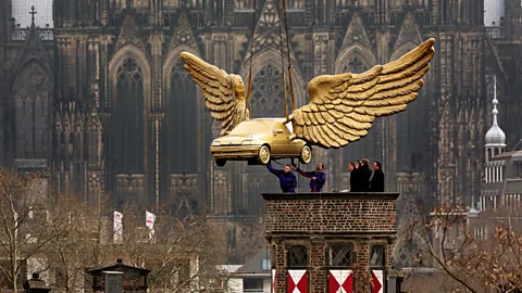 Getty Images Workers install on artist HA Schult’s golden winged car on the roof of the City Museum in Cologne, Germany, after its restoration at Ford. (Copyright: Getty Images)