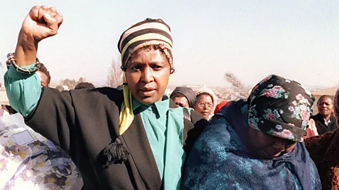 Winnie’s more militant look, worn as she raises a clenched fist during the 1987 funeral of Sello Motau, senior member of the ANC military wing. (Getty Images)