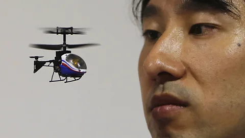 Reuters A Japanese toymaker watches the world’s smallest infrared remote-controlled helicopter hover in front of him, ahead of the International Toy Show in Tokyo. (Copyright: Reuters)