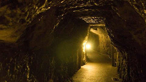 Dimly lit underground tunnel .