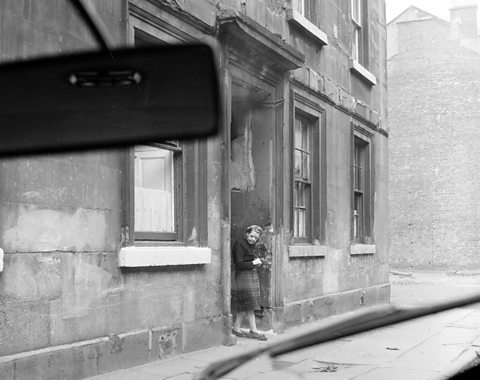 A car driving through the Gorbals area of Glasgow in 1963