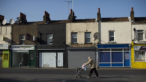 A rundown high street with closed shop fronts