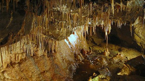 Inside a cave with stalactites and stalagmites