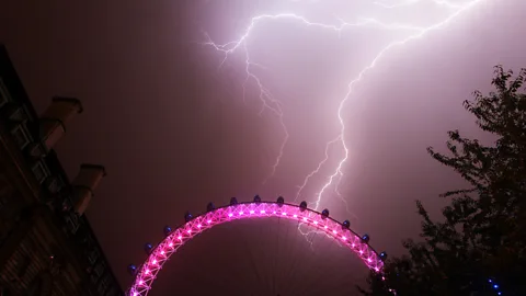 PA Lightning strikes behind the London Eye in central London. Electrical storms broke out over southern England this week after days of sweltering weather. (Copyright: PA)