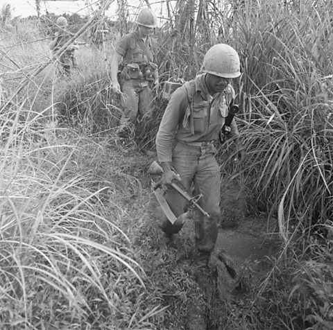 Saighdearan nan SA a' coiseachd tro dhlùth-choille