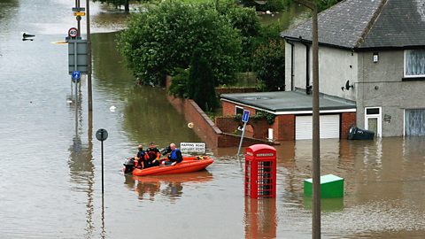 People in an emergency boat in a flood in Rotherham, UK