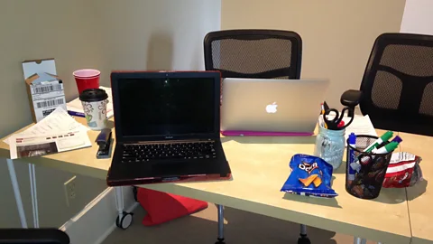 Empty snack bags and coffee cups on a shared worktable. (Influence & Co.)