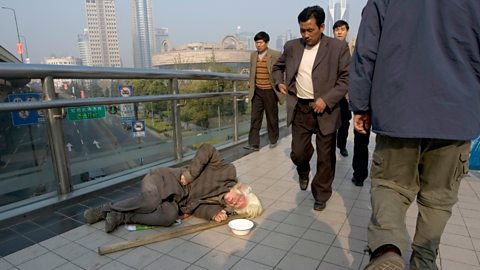 People walking past homeless person. People's square. Shanghai. China