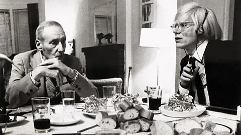 William S Burroughs and Andy Warhol having dinner at New York's Chelsea Hotel.