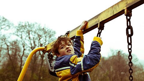 Actor ifanc yn hongian o ffram swing i hyrwyddo Ma' Bili'n Bwrw'r Bronco