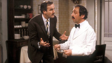 John Cleese fel Basil Fawlty ac Andrew Sachs fel Manuel yn y gomedi sefyllfa Fawlty Towers