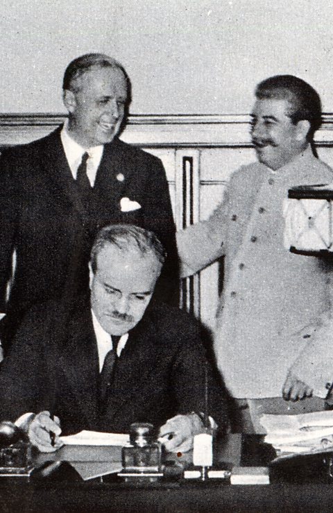 Stalin and von Ribbentrop share a joke as Molotov signs document