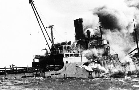 Half submerged ship engulfed in smoke