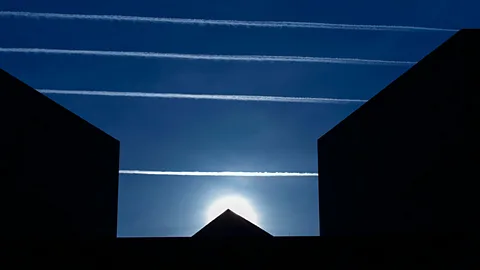 Contrails from jets flying overhead form a backdrop behind the National Museum of Art in Washington DC. (AP)