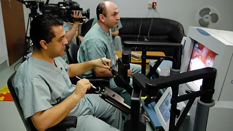 Mehran Anvari controls his robot surgeon, conducting a keyhole surgery (St Joseph's Healthcare)