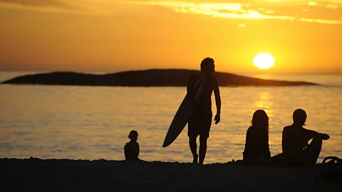 Sunbathers and surfers enjoy the sunset in Cape Town's Camps Bay. (Stephane de Sakutin/AFP/Getty)