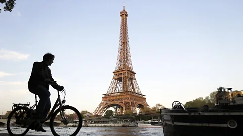 A man cycles along river Seine in front of the Eiffel Tower. (Kenzo Tribouillard/AFP/Getty Images)