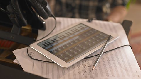 Computer tablet on top of a piano with music app