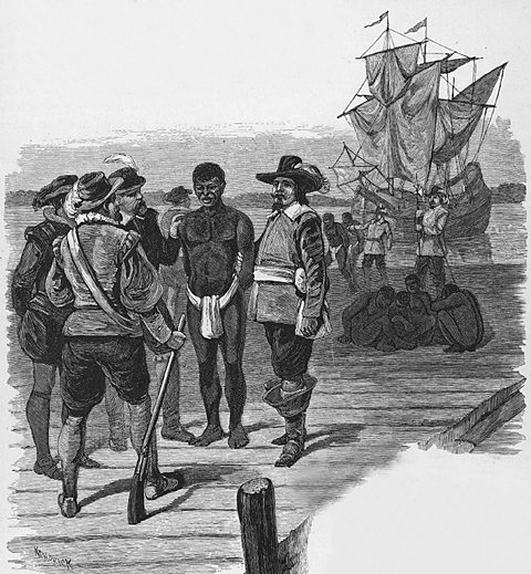 A group of men stand on a dock and examining an enslaved African person. In the background another group of enslaved people sit on the dock.