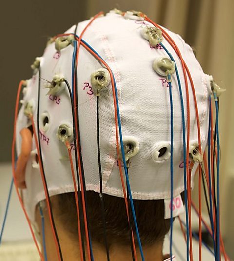 Photograph of man with an electroencephalogram (EEG) on his head. 