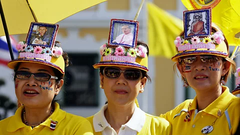 Women wear hats with pictures of Thai King Bhumibol Adulyadej. (Chumsak Kanoknan/Getty)