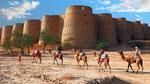 A caravan of camels passes by Derawar Fort, Cholistan Desert in the afternoon. (Sami's Photography/Getty)
