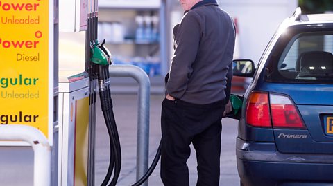 A man filling his car up at a petrol station 