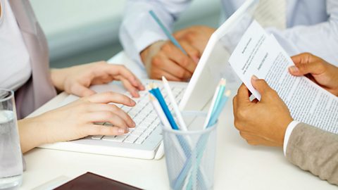 A group of office workers with one person looking at a report.