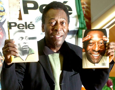 Pelé, internationally renowned Brazilian football player holding his biography.