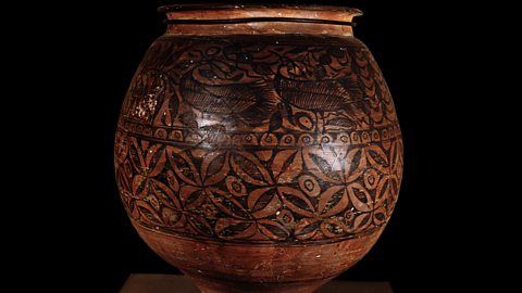 A terracotta pot decorated with painted birds