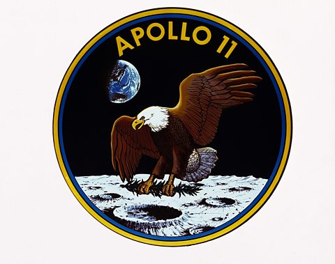 The Apollo 11 mission badge showing an eagle on the moon. 