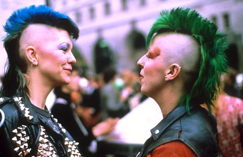A man and a woman with colourful Mohawks. 