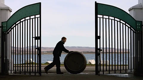Jeff J Mitchell/Getty Images Pushing a barrel of Bruichladdich whisky. (Credit: Jeff J Mitchell/Getty Images)