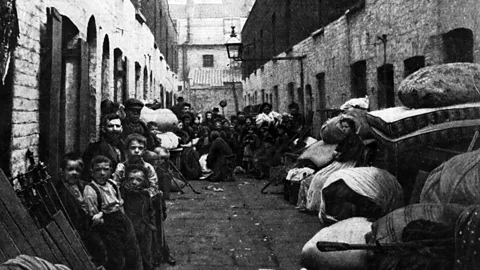 Hulton Archive/Getty Images A family in London's slums sits in the street, surrounded by their possessions in the street, after being evicted from their home in 1901 (Credit: Hulton Archive/Getty Images)