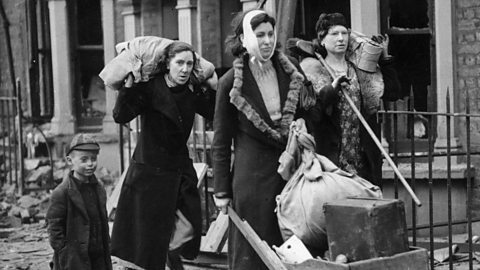 Women leave their ruined homes in the East End of London