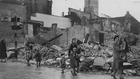 Residents trudge past devastated buildings in Plymouth