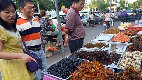 Tang Chhin Sothy/AFP/Getty Images Happily picking from the baskets of beetles (Credit: Tang Chhin Sothy/AFP/Getty Images)