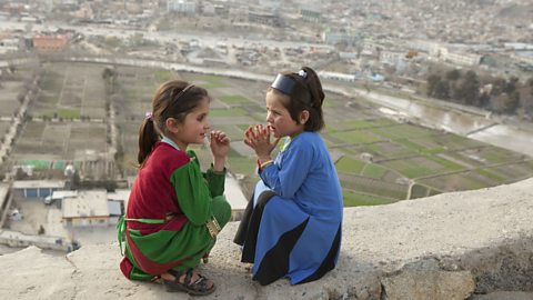 Two young girls on a wall in Kabul, Afghanistan