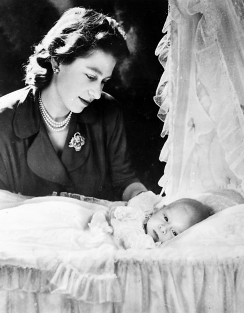 A black and white photograph showing Queen Elizabeth II with a young Charles Philip Arthur George.