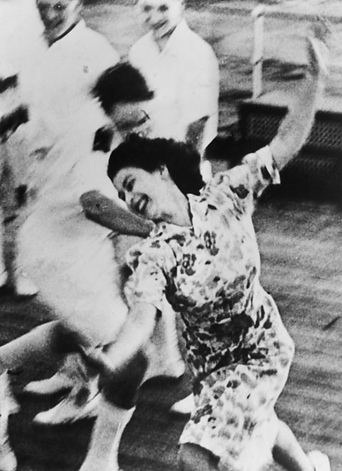 A black and white photograph showing Princess Elizabeth playing deck games on board a Royal Navy ship.