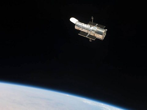 The Hubble Space Telescope floating above the Earth