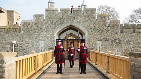Richard Lea-Hair/Historic Royal Palaces Yeoman Warders stand on the Tower of London’s drawbridge, which was reinstated in 2014 (Credit: Richard Lea-Hair/Historic Royal Palaces)