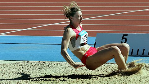 Flexion of the hip joint as a long jumper lands in the sand